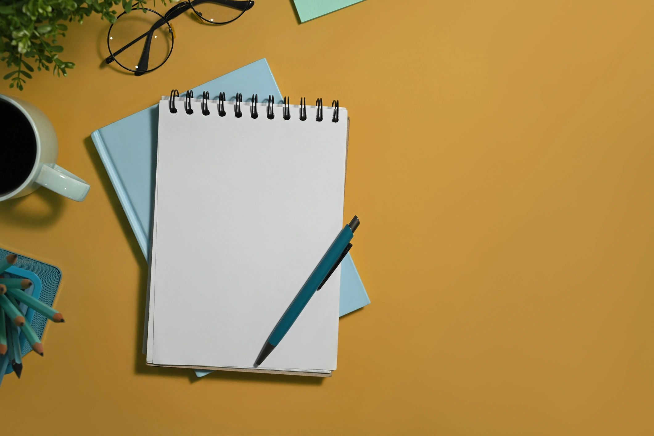 Notepad and pen with coffee in a bright flat lay