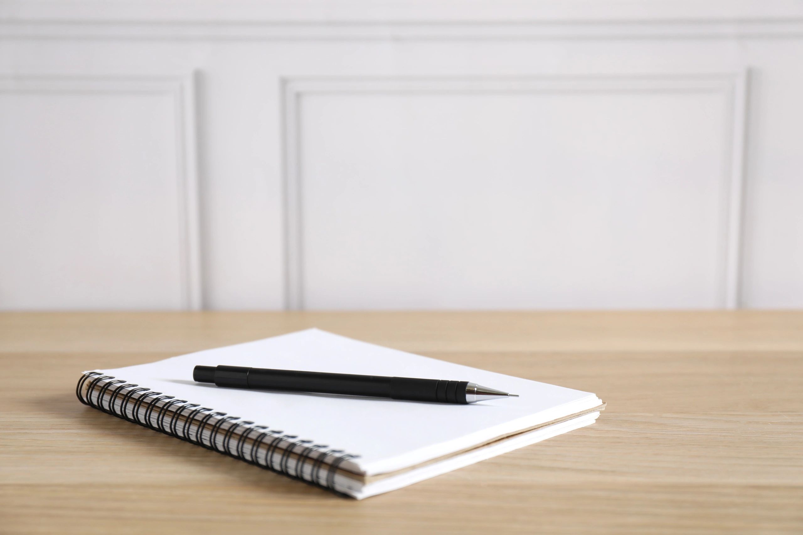 Open notebook and pen on a wooden desk